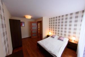 a bedroom with a bed and two lights on two tables at Villa Turris in Muszyna