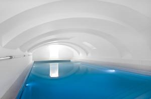 ein Schwimmbecken in einem Tunnel mit blauem Wasser in der Unterkunft Zenden Hotel Maastricht in Maastricht