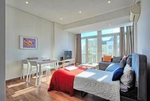 リスボンにあるAlameda Flatのベッド、テーブル、ソファが備わる客室です。