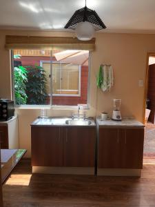 a kitchen with a sink and a window at Cabañas Kimaya El Quisco in El Quisco