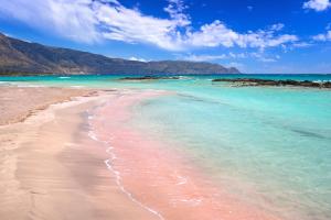 uma praia com água azul e montanhas ao fundo em Nemesis em Plátanos