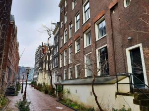an empty city street with tall brick buildings at Houseboat Amsterdam - Room with a view in Amsterdam