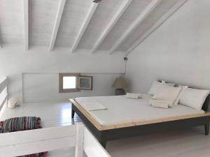 a white room with a bed and a window at Notus Villa in Chorto