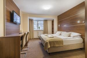 pokój hotelowy z łóżkiem, biurkiem i telewizorem w obiekcie Pokoje gościnne Nord w mieście Krynica Morska