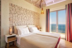 une chambre avec un grand lit avec un mur en pierre dans l'établissement My Villa Corfu, à Nisakion 72 autres photos