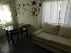 sala de estar con sofá y mesa de comedor en MViejo en Puerto Madryn