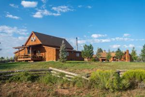 a large wooden house on a grassy field at Beautiful 1 BR "Barn" Cabin - Perfect for Small Families in Panguitch