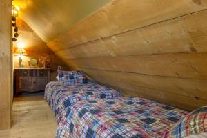 two beds in a room with a wooden ceiling at Beautiful 1 BR "Barn" Cabin - Perfect for Small Families in Panguitch
