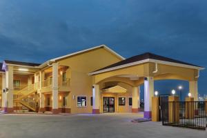 a large building with a gate in a parking lot at Days Inn by Wyndham Odessa in Odessa