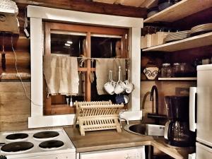 a kitchen with a sink and a stove top oven at Hilupilttuu in Tammela