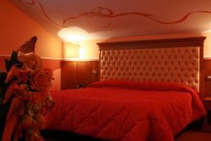 ein Schlafzimmer mit einem roten Bett mit einer roten Bettdecke in der Unterkunft MARCHESINA RESORT srls in Teggiano