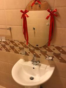 a bathroom sink with red bows on a mirror at Layali Alandlous Furnished Units in Al Qunfudhah