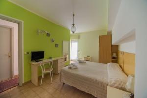 1 dormitorio con 1 cama y escritorio con TV en Miramonti en Calizzano