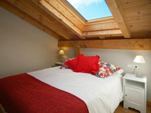 Un dormitorio con una cama con almohadas rojas y una ventana en Apartamentos Lusarbe, en Orio