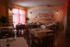a restaurant with tables and chairs and a painting on the wall at MARCHESINA RESORT srls in Teggiano