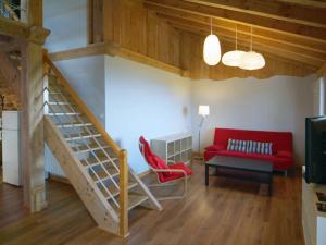 a living room with a red couch and a staircase at Apartamentos Lusarbe in Orio