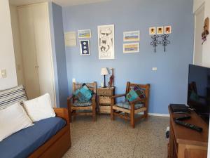 Habitación con 1 cama, 2 sillas y TV. en Luminoso Apartamento en Aidy Grill, en Punta del Este