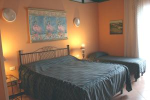 デイヴァ・マリーナにあるHotel 5 Terre Nel Soleのベッドルーム1室(ベッド2台付)が備わります。壁には絵画が飾られています。