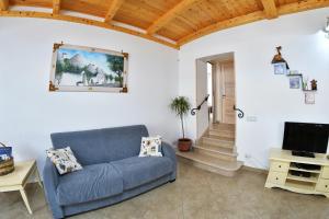 un soggiorno con divano blu e TV di Marghegio' house a Ceglie Messapica