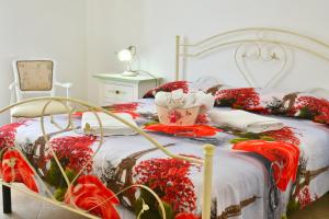 Un dormitorio con una cama con flores rojas. en Marghegio' house, en Ceglie Messapica
