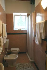 a bathroom with a toilet and a window at Hotel 5 Terre Nel Sole in Deiva Marina