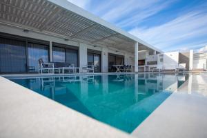 een zwembad met blauw water in een gebouw bij Villa Nissos in Lindos