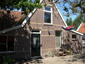 a brick house with a kite hanging from it at De iisfugel in Gaast