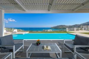 uitzicht op een zwembad vanaf de patio van een huis bij Villa Nissos in Lindos