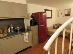 eine Küche mit einem roten Kühlschrank neben einer Couch in der Unterkunft Emozione Bologna Sant Orsola in Bologna