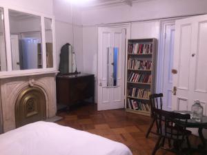 a bedroom with a fireplace and a table with a mirror at Illumination Bed & Breakfast in Brooklyn