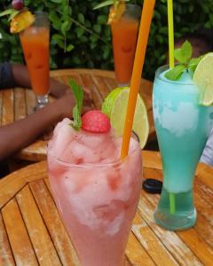 a drink on a table with a strawberry and lime at Kanalu Studio in Bouillante