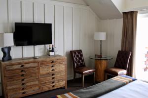 a bedroom with a television on a dresser with two chairs at Sunnyside Resort and Lodge in Tahoe City