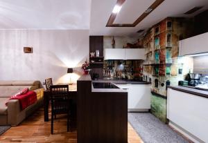a kitchen and a living room with a couch at Apartament MODERNA Francuska Park in Katowice