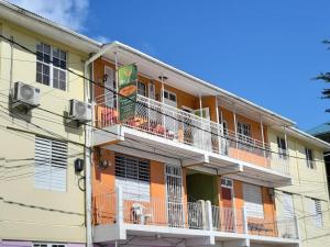 an apartment building with a balcony with a dog on it at Narakiel's Inn in Roseau