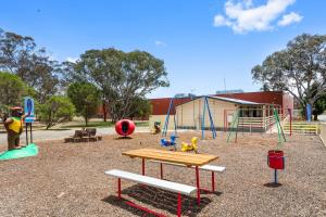 un parque infantil con mesa y columpio en Goulburn South Caravan Park, en Goulburn