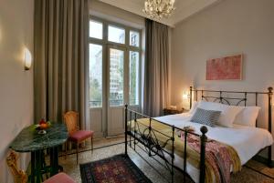 um quarto com uma cama, uma mesa e uma janela em Athenian Vintage Apartments em Atenas