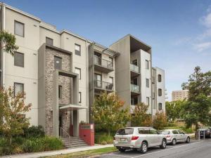 two cars parked in front of a building at ReadySet Apartments on Altona in Melbourne