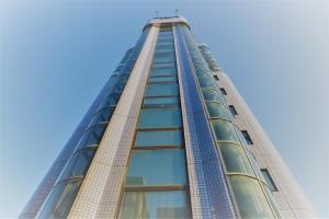 un grand bâtiment avec un ciel bleu en arrière-plan dans l'établissement Hotel ACQUA MYU, à Fukuoka