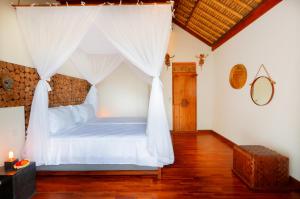 a bedroom with a bed with a canopy at Villa Arcadia in Gianyar