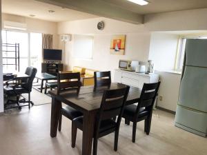 una cucina e una sala da pranzo con tavolo e sedie di Eagle Lodge a Chatan