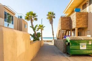a street next to a building with palm trees and the ocean at Fantastic Mission Beach condo steps to the Beach in San Diego