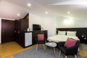 Habitación de hotel con 1 cama y 2 sillas en VovaDoma en Tiflis