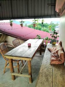 a wooden table and chairs in a room with a window at Stay in Kampot in Kampot