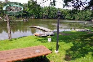 a park bench next to a lake with a dock at Edgewater Inn & Cottages in Eagle River