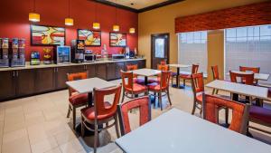 a dining room with tables and chairs in a restaurant at Best Western Executive Inn El Campo in El Campo