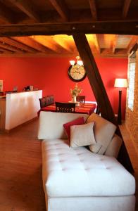een woonkamer met een witte bank en een rode muur bij l'HORIZON in Saint-Yrieix-la-Perche