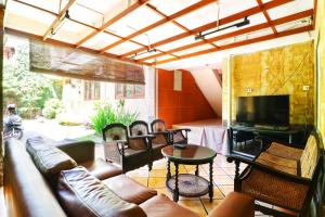 a living room with a couch and a television and a table at RedDoorz Plus near Brawijaya Museum in Malang