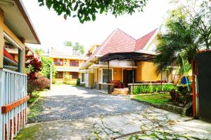 a house with a driveway in front of it at RedDoorz Plus near Brawijaya Museum in Malang