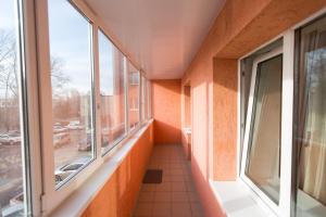 un couloir vide avec fenêtres dans un bâtiment dans l'établissement Apartments Tomsk House na Gogolya, à Tomsk