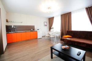 Il comprend un salon avec un canapé et une cuisine. dans l'établissement Apartments Tomsk House na Gogolya, à Tomsk